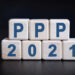 PPP 2021 text on wooden cubes on a black background with reflection.