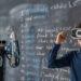 Contemporary student in vr headset raising hands by blackboard while making presentation of abilities of robot at lesson