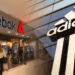 Adidas vende Reebok por cifra multimillonario, comercio internacional, tiendas de ropa en centro comercial iluminado