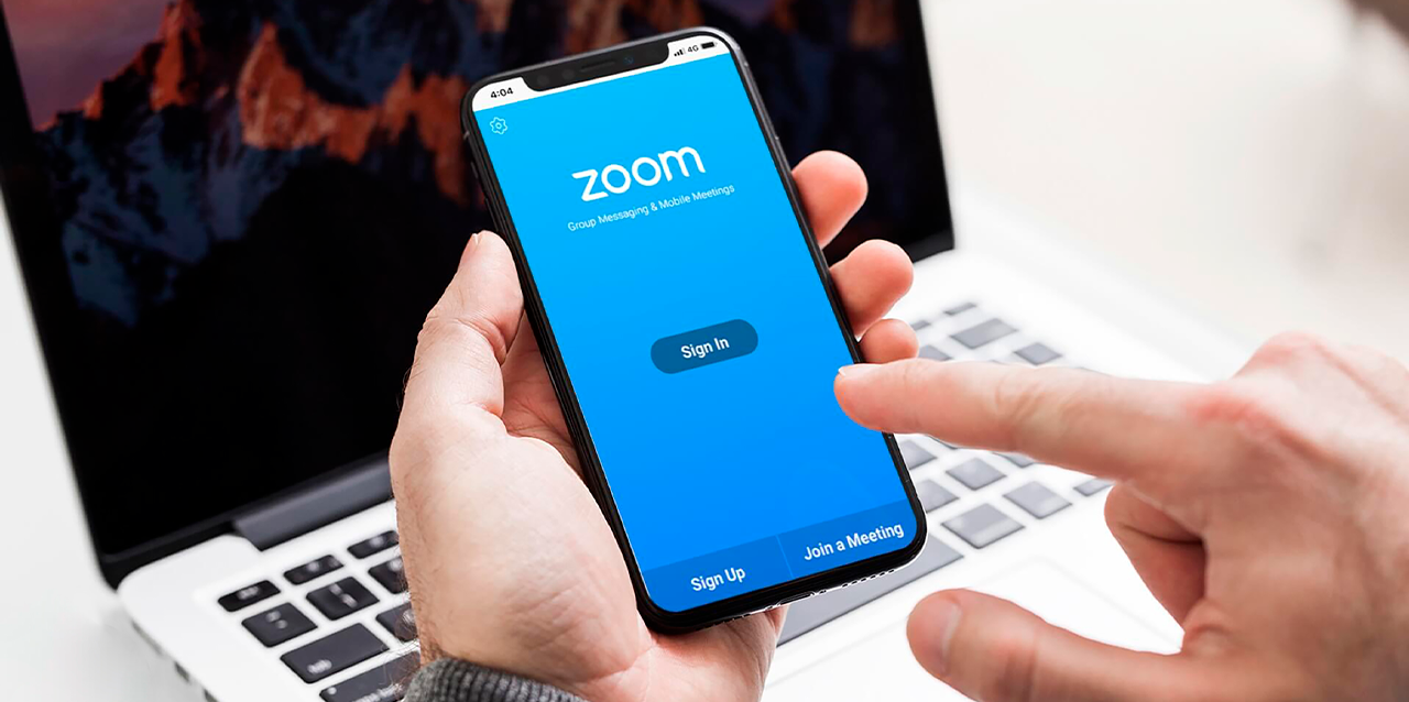 Hombre joven usa la plataforma Zoom desde su iPhone