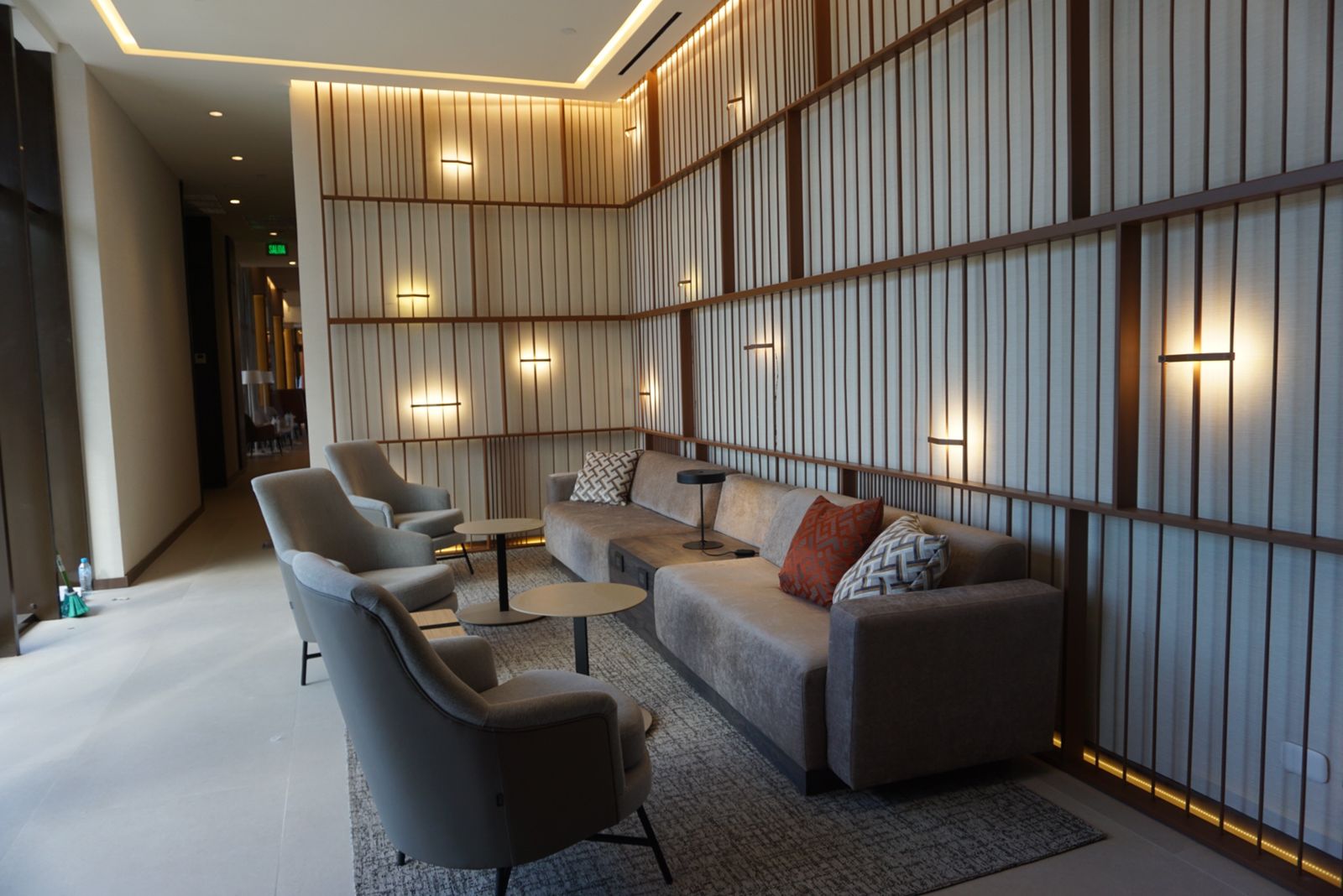 Sala de estar común del hotel, con diseño moderno y muebles grises.