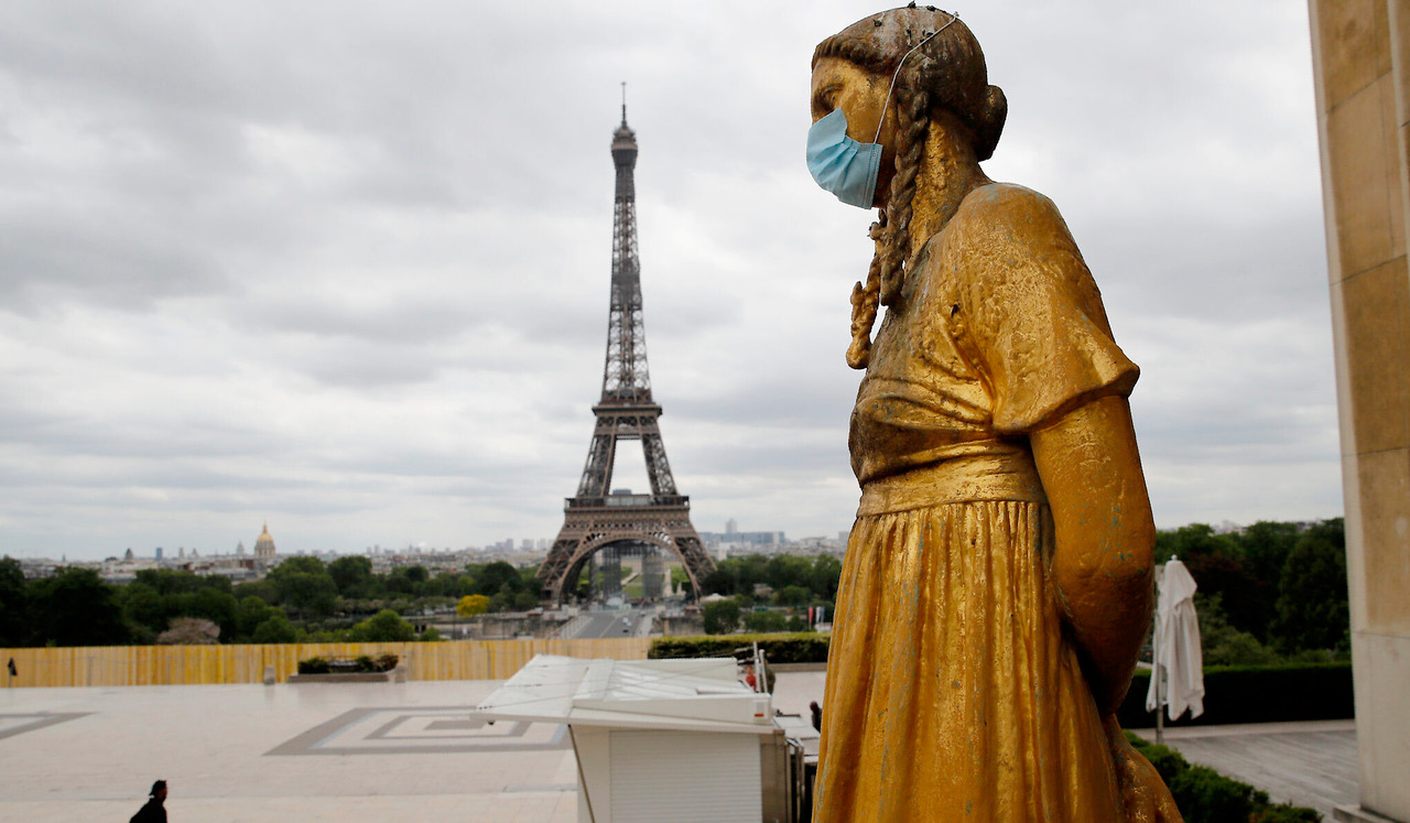 Estatua con mascarilla cerca de la Torre Eiffel en Francia.