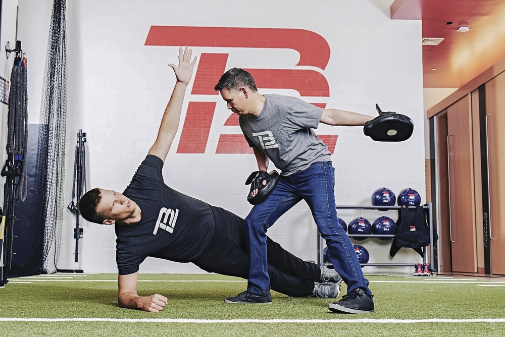 Body Coach entrenando a cliente en centro TB12 de Boston