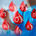 doctor marca pizarra con gotas de sangre de caricatura que representan todos los tipos de sangre