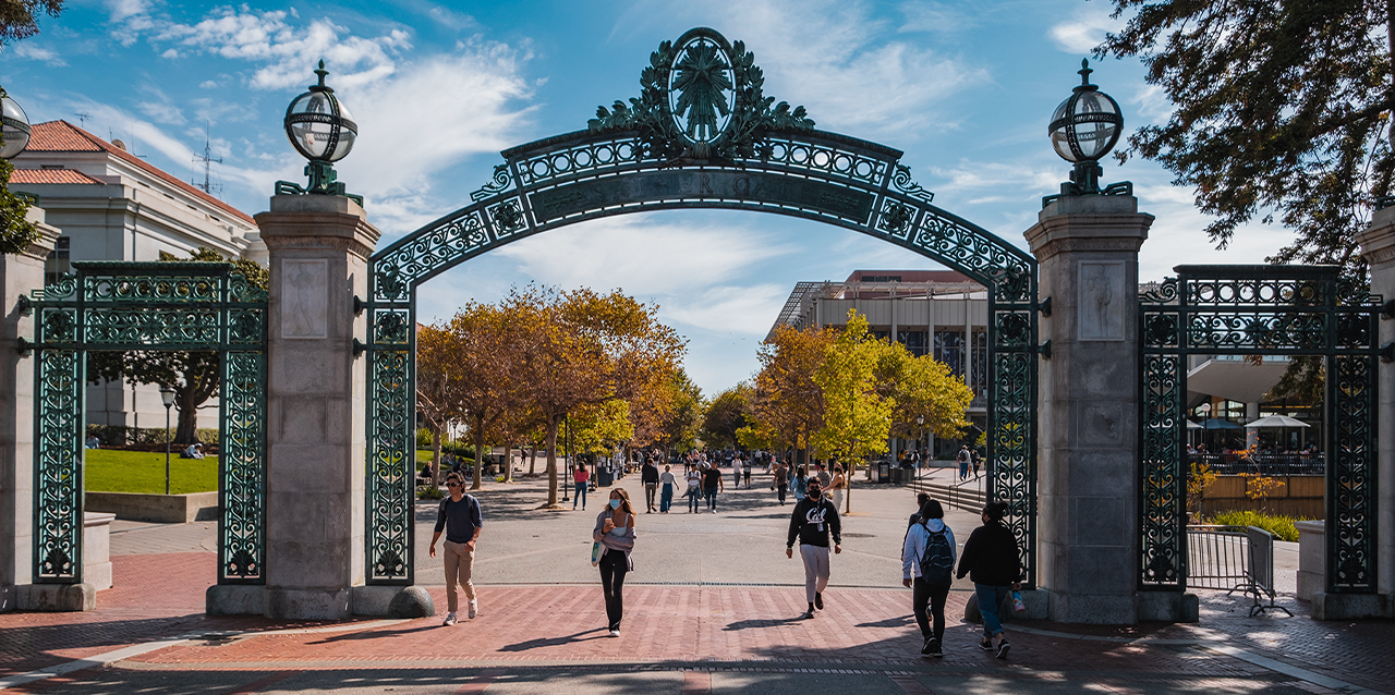 Estudiantes caminan cerca de la puerta principal del campus de UC Berkeley
