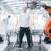 Denis Sverdlov de pie rodeado de máquinas en fábrica de producción