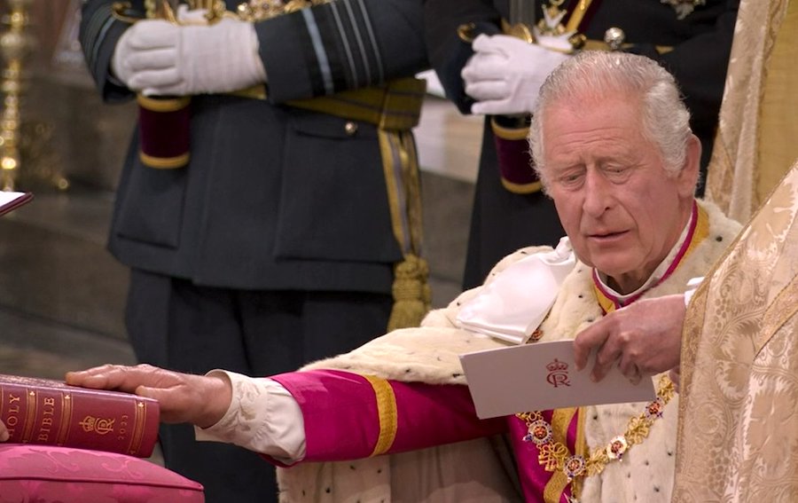 El rey Carlos III se arrodilla y coloca sus manos sobre la Biblia de la Coronación para hacer su juramento de Coronación.